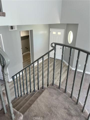 Stairs and view of front door and laundry room/garage access