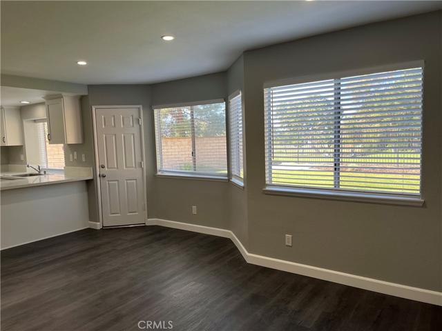 Partial view of kitchen, family room and breakfast nook leading to backyard