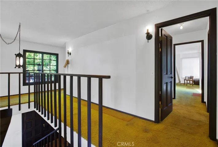 Second level hallway with view into secondary bedroom.
