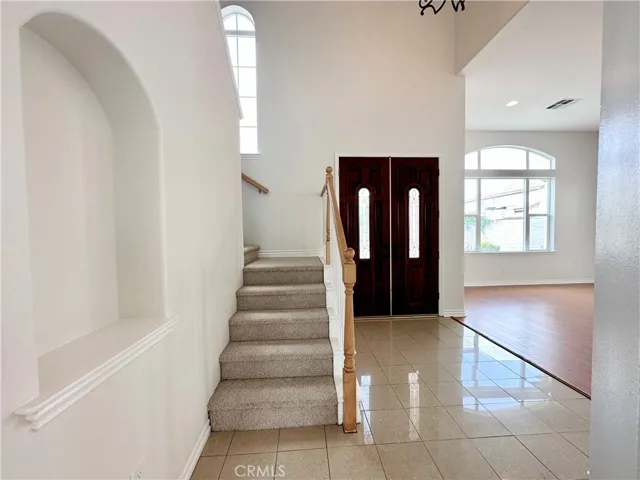 View of front door and stairway from kitchen