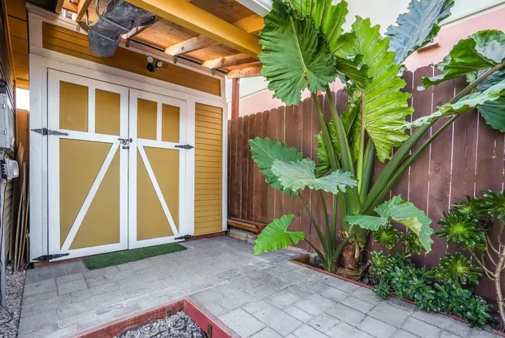 Custom tool shed behind garage that conveys