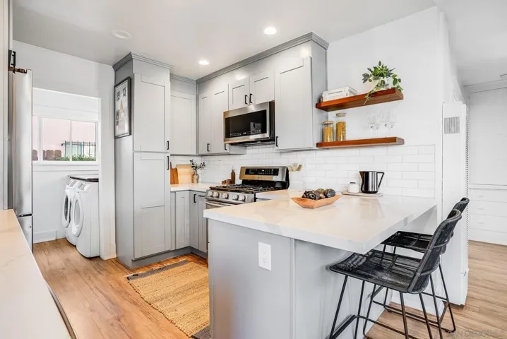Fully remodeled kitchen with eat-in bar top, stainless steel appliances, built-in pantry and 5 burner gas stove! VERY unique for a bungalow like this.
