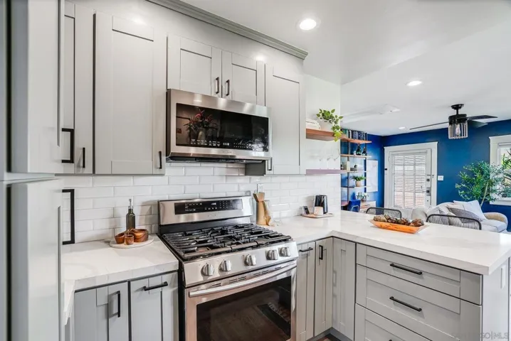 Fully remodeled kitchen with eat-in bar top, stainless steel appliances, built-in pantry and 5 burner gas stove! VERY unique for a bungalow like this.
