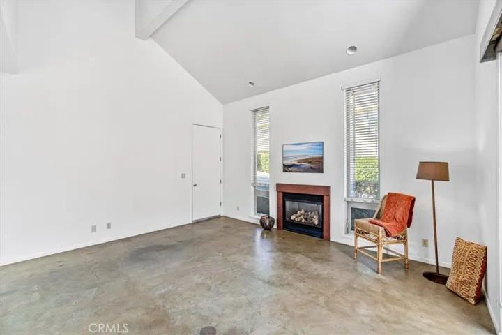 Spacious livingroom with modern concrete floors, gas fireplace and tons of natural light