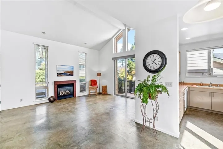 Living area with vaulted ceilings and concrete floors