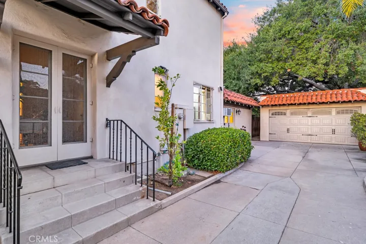 Driveway past gate. Steps to office and two car garage.