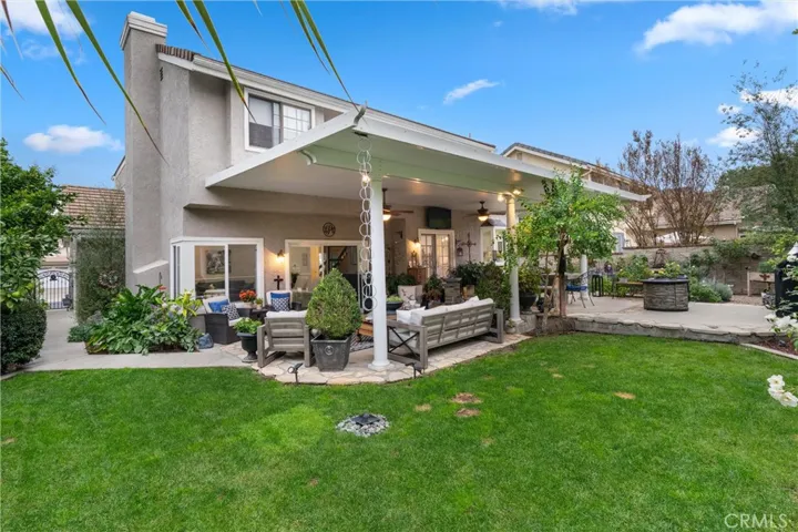 The expansive backyard features a grass area for playing, and English garden for admiring, and a covered patio with lighting and fans for entertaining.
