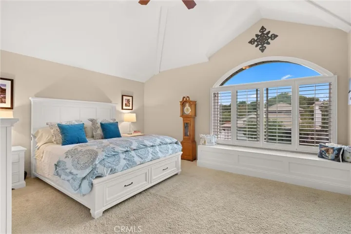 The primary suite features vaulted ceilings, an oversized picture window, and a beautiful window seat with storage