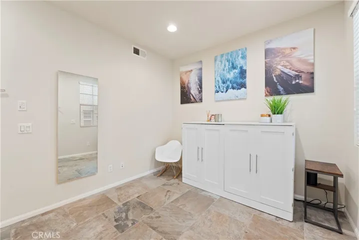 Ground floor entry currently used as a guest space and home office. This has a closet and window & can serve as a 3rd bedroom or flex space. Stairs leading to the 2nd level are on the same wall as the closet door.