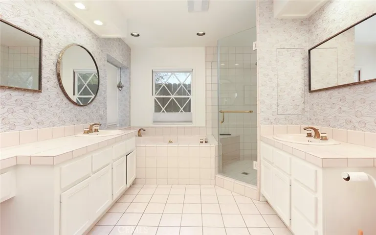 Primary bathroom with two vanities and separate shower and tub.