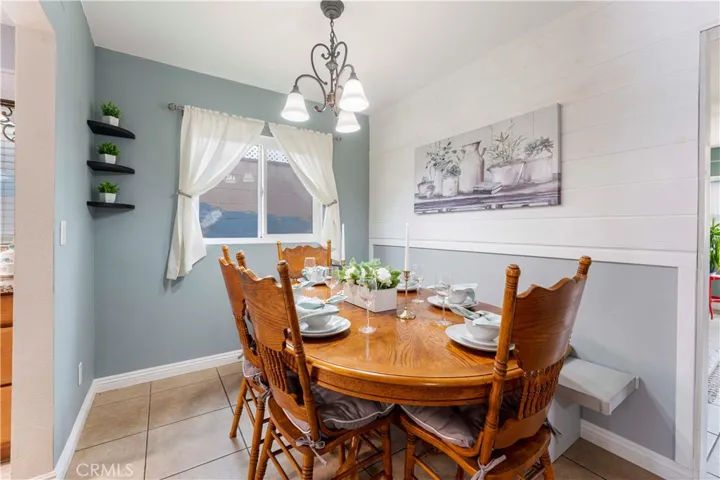Dining area off from galley kitchen. If you desire a more open space living style, then one can open this wall up. Current home owners put the wall up to separate and have the family room in its own space. Window view of side yard with block wall that has a mural painted on it.