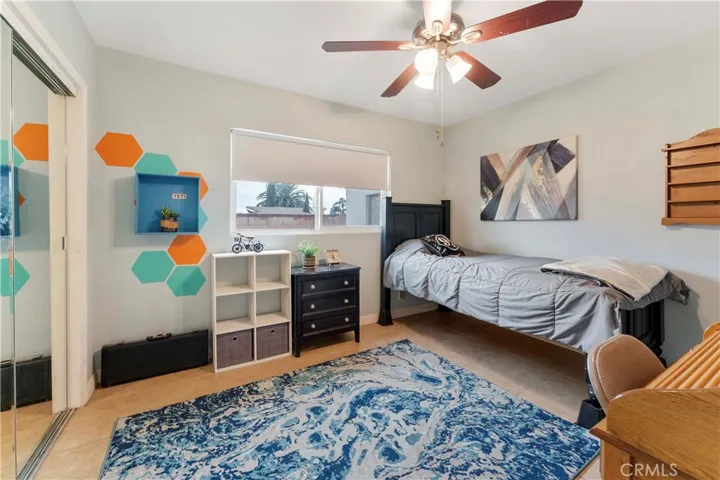 Plenty of room in this bedroom with ceiling fan and mirrored closet doors at the end of the hallway on the right side nearest the full bathroom.
