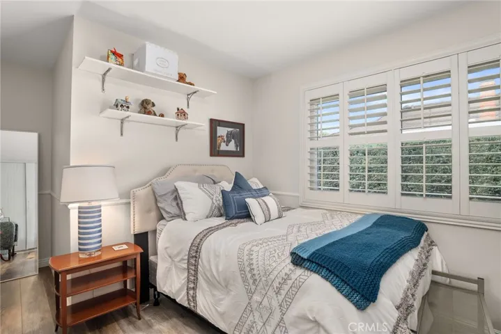 Guest bedroom with wood flooring.
