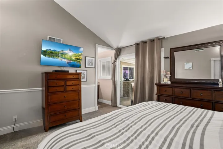 Primary bedroom with a sliding glass door leading to the patio and pool area.