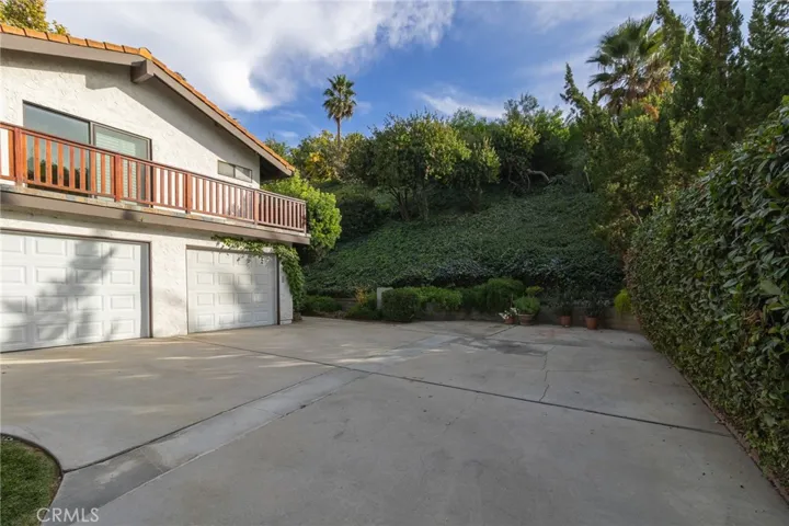 Driveway area for parking with view of balcony from primary bedroom.
