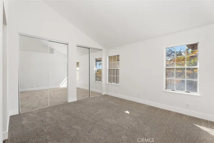 Large Master with dual closet, new carpeting and screens as well as mirrored wardrobe doors, shelving and hanging rods