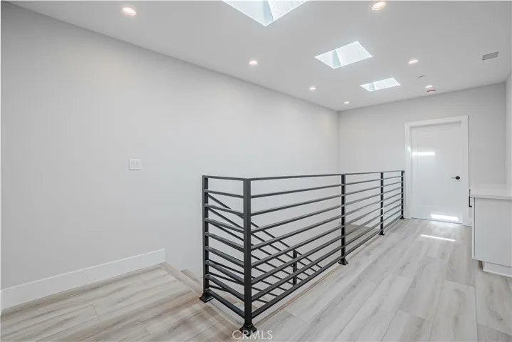 3rd level view of staircase, hallway and door to en-suite (door closed).