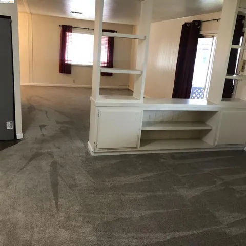 Separated living room spaces by open shelving unit