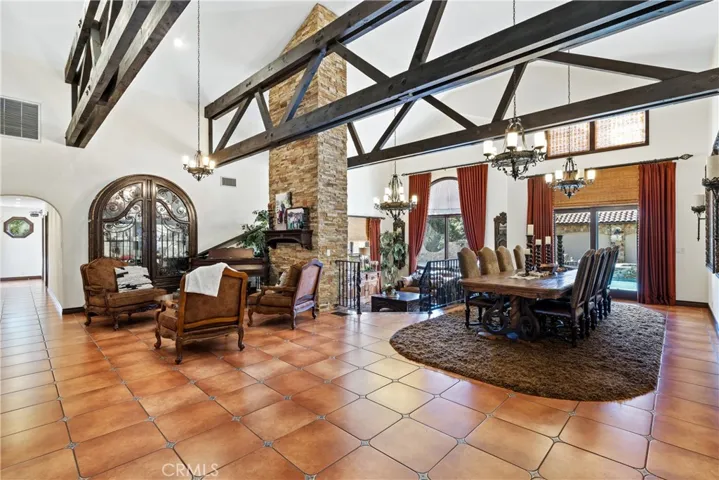 Reception foyer, formal dining, and living room. Custom drapery and backyard access through French doors.