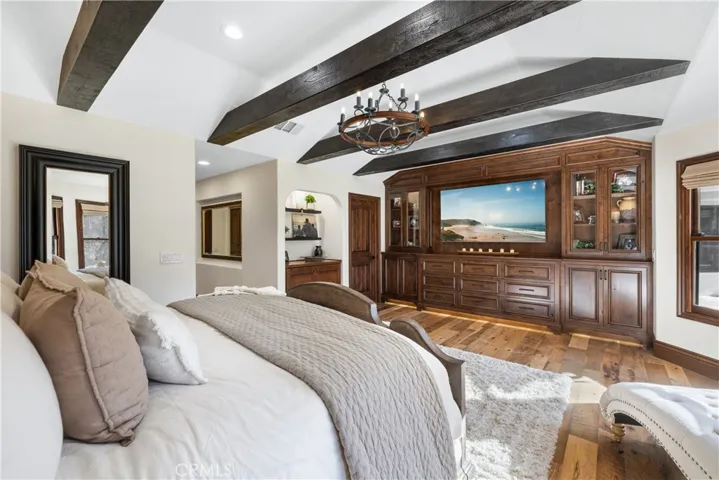 Primary bedroom toward the custom built-in cabinetry with flush TV space.