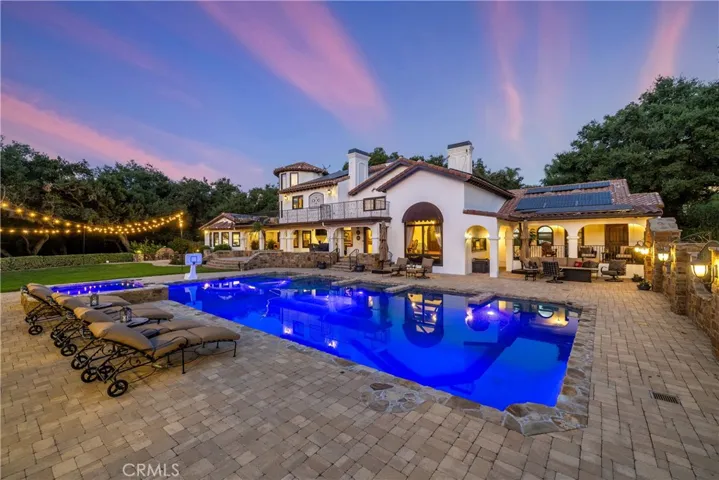 Back elevation from behind the pool showing the paver decking and LED pool lighting.