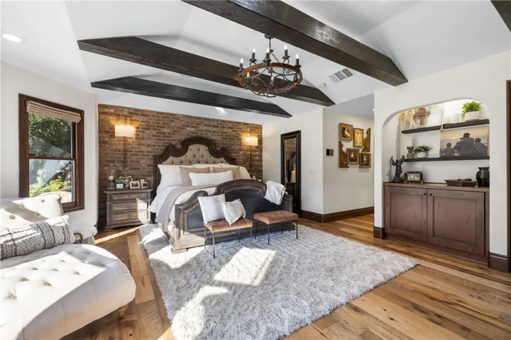 Primary bedroom toward the primary ensuite bathroom featuring a handcarved barn door from Turkey.