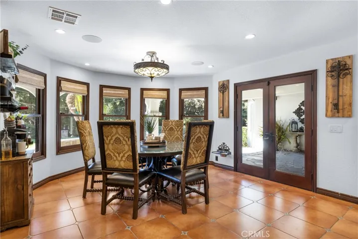 Breakfast nook looking toward the backyard windows featuring automatic shades and French doors leading to the backyard.