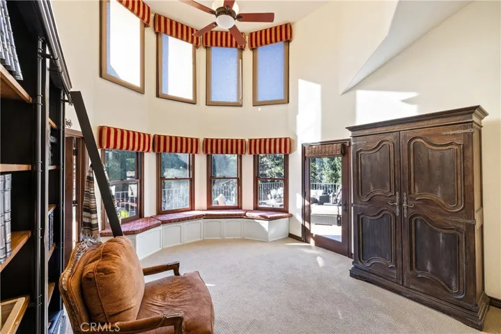 Loft with a door to an oversized balcony.