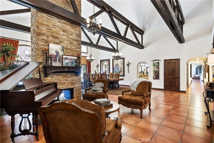 Entry foyer reception area with dramatic open beamed ceilings and a double sided floor-to-ceiling fireplace.
