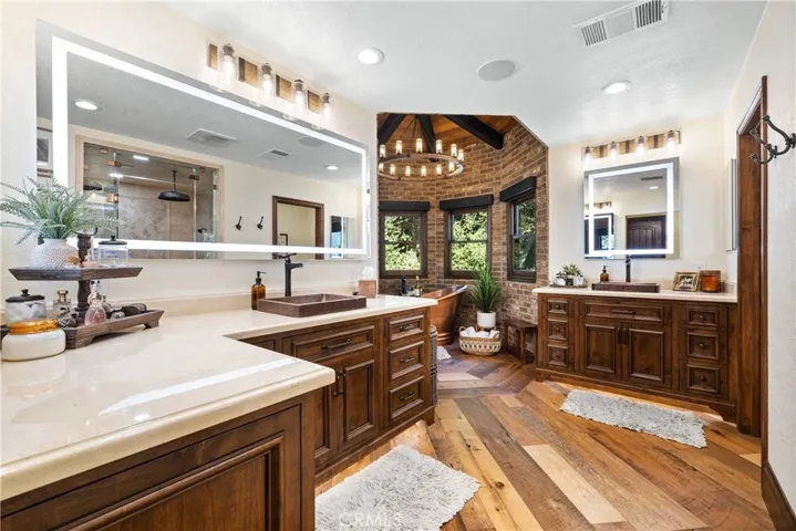 His and her vanities with custom lighting, LED lit vanity mirrors, and 100 year old barn wood floors.