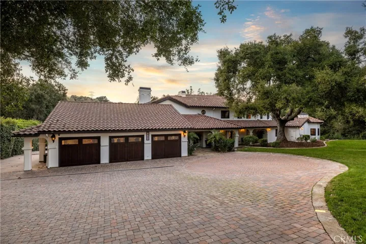 Front elevation, the entire driveway is laid with pavers and has runway light down the sides. The attached three car garage is extra deep and there is a standard staircase accessible at the back corner ascending to exceptional overhead storage that is fully walkable.