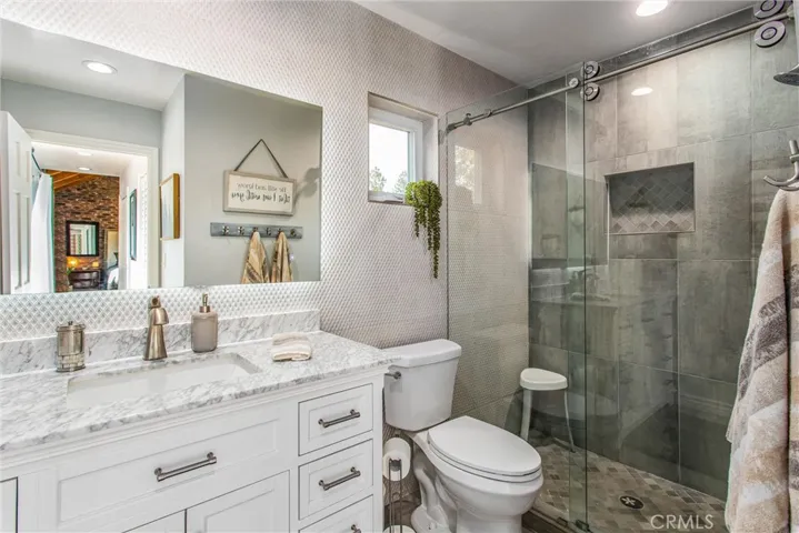 Newly remodeled bathroom has Italian tile wall and "barn" roller doors on shower.  Beautiful!