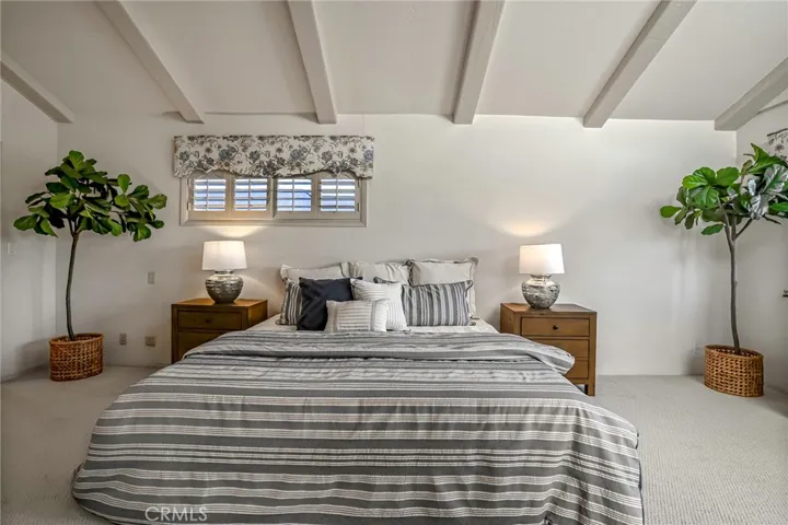 Primary Bedroom is south side with high beamed ceilings.