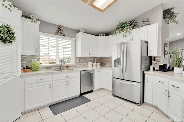 Remodeled kitchen with granite counters with beveled edge, stainless appliances, and tile back splash.