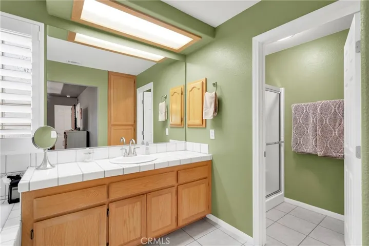 Primary bedroom suite features a soaking tub with large vanity area, and a separate shower and toilet room.