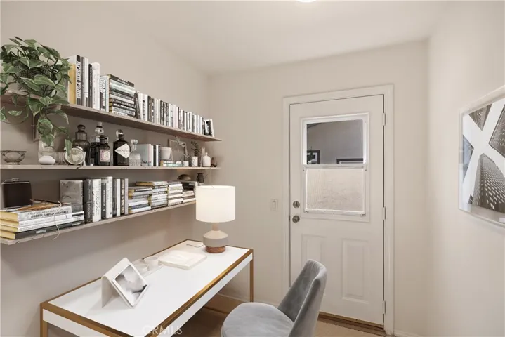 Bonus/utility room, virtually staged as an office, previously housed washer/dryer. The door leads to the double-gated side yard.