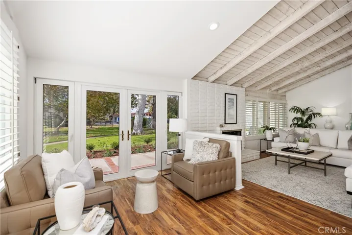 The conversational seating area looks out French doors to the greenbelt.