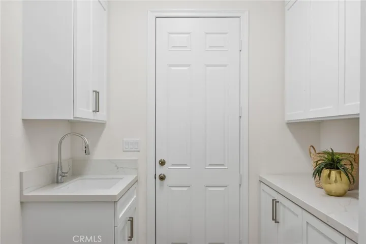 Laundry Room just off the Primary Bedroom has new cabinets and countertops, with a door that leads outside