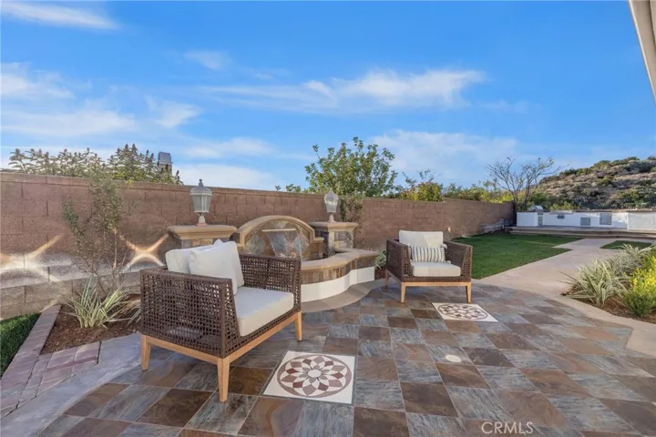 Patio off the living/dining room with water feature that leads to a BBQ and outdoor cooking area