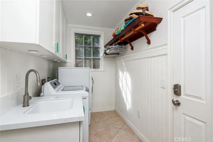 Laundry room is on the mail floor. Lots of hanging space for clothing and storage space for laundry products above the machines. Door on right leads to the garage.