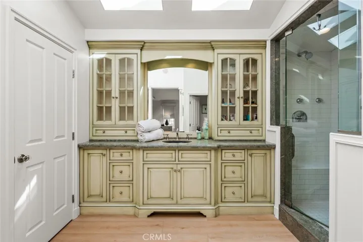 Primary Bathroom has 2 walk-in closets. Artisan built vanity with plenty of storage. Electrical outlets upper cabinet as well as lowest drawers. Designed with single sink but piping still exists if want to redo to dual sinks.