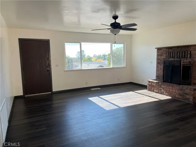 Living room features classic brick fireplace and ceiling fan