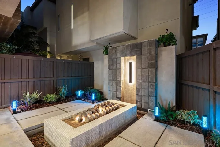 The backyard has a wall waterfall that flows into the moat below.  There is a gas firepit with plantings (all on auto drip system).  Low-voltage lights surround the area and can be made to change color.