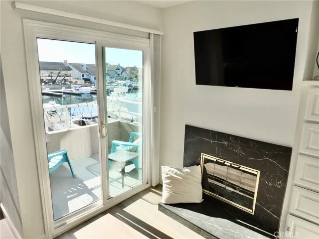 Balcony off primary bedroom with view of water & newly tiled fireplace