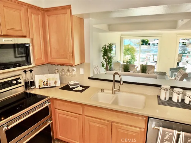 Kitchen overlooks dining room & living room towards patio & water