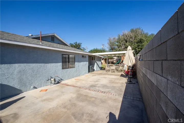 The concrete side patio leads you to the backyard.