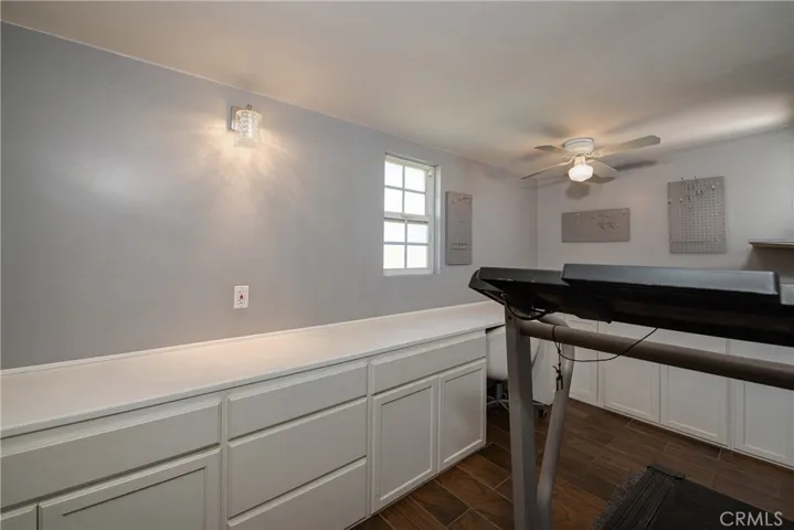 The bonus room is in the back of the home and has numerous cabinets and a built-in desk.