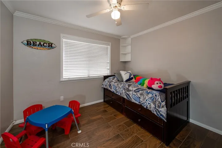 Bedroom 2 has crown molding, a ceiling fan and large window to let the natural light flow.