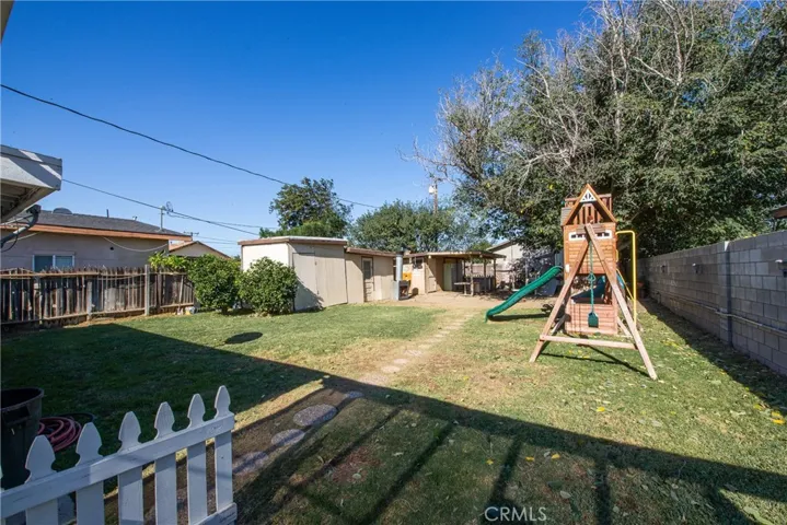 The large backyard has two sheds, a workshop, a travel trailer and a fish pond.