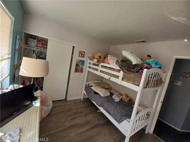 Bedroom with large closet and vinyl plank flooring.